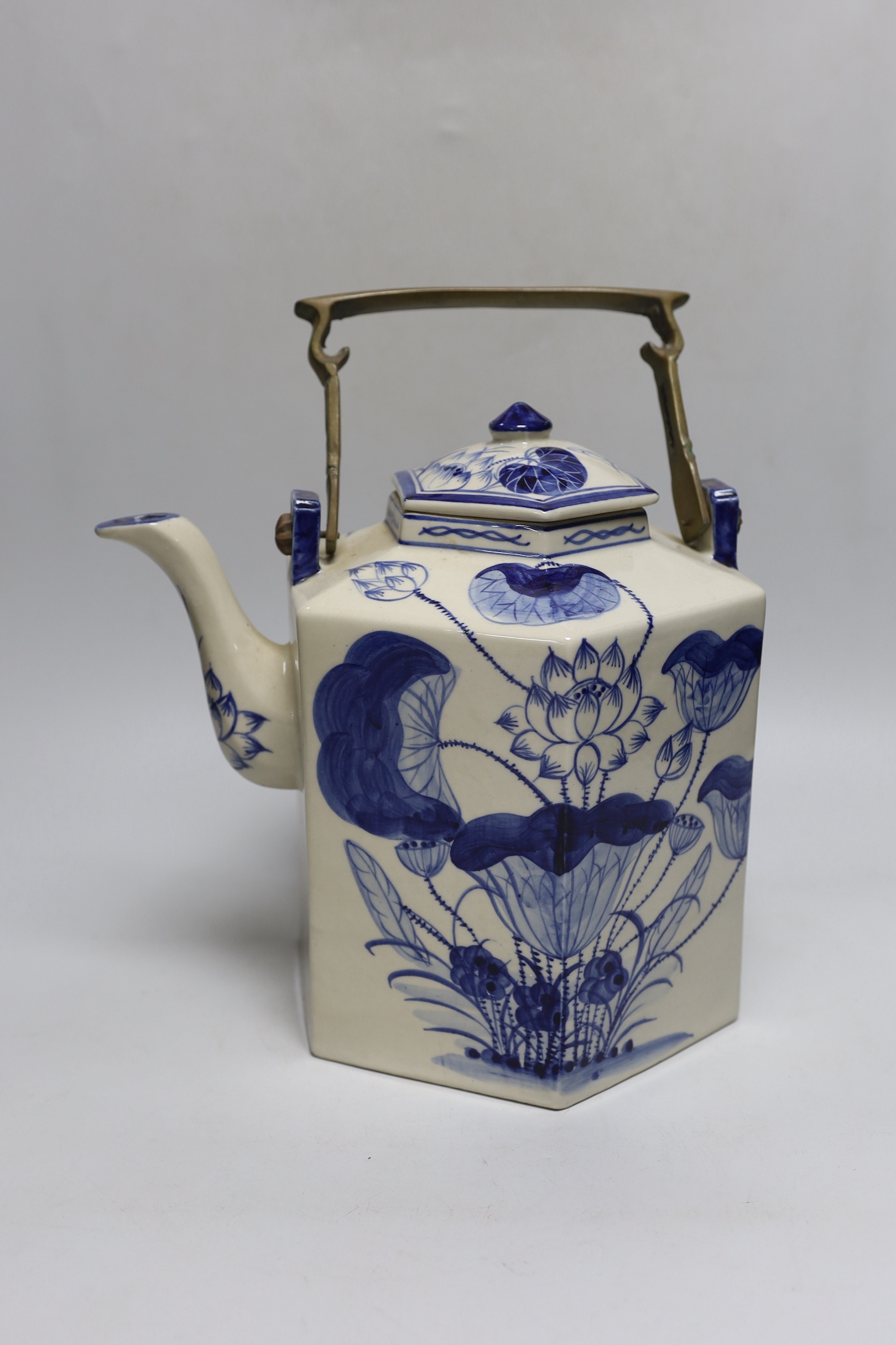 A Chinese blue and white oversized hexagonal teapot, with brass fitted handle and floral decoration, 30cm tall